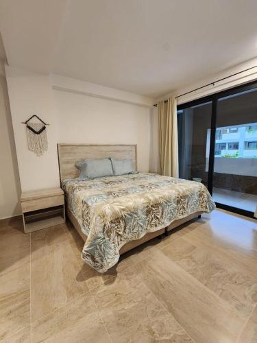 a bedroom with a bed and a large window at Hermoso y nuevo departamento en Nuevo Vallarta in Jarretadera