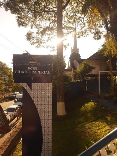 a sign in front of a building with a church at Hotel Cidade Imperial in Petrópolis