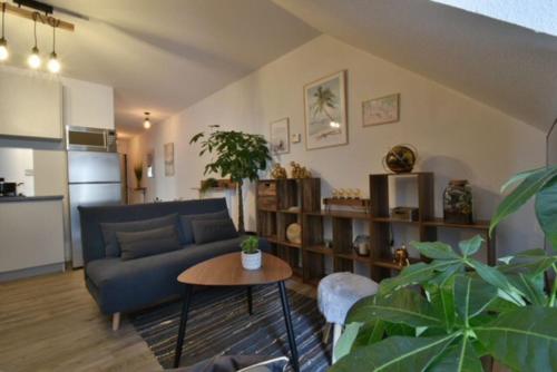 sala de estar con sofá azul y mesa en Appartement BELLO , ruelle au cœur de ville, arrivée en autonomie, en Lons-le-Saunier