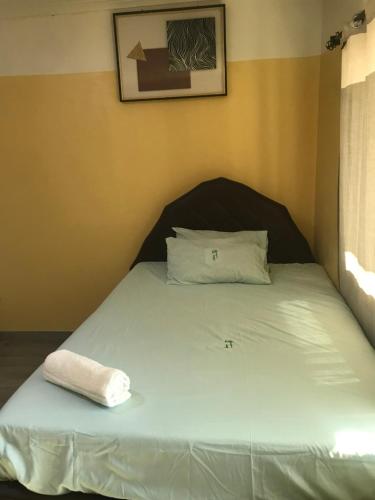 Una cama con una toalla blanca encima. en Awesome Executive Lodge, en Solwezi