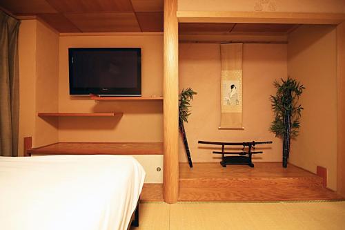 a bedroom with a bed and a tv and a table at TOKYO HOUSE INN - Vacation STAY 02084v in Tokyo