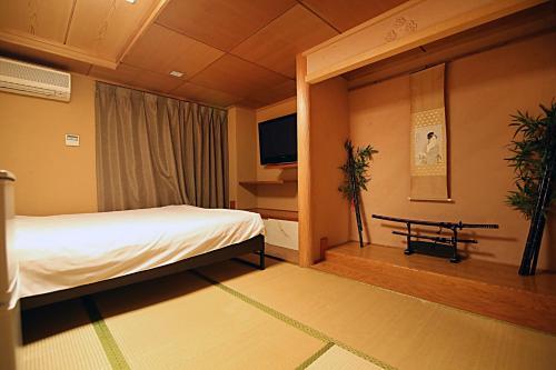 a hotel room with a bed and a tv at TOKYO HOUSE INN - Vacation STAY 02084v in Tokyo