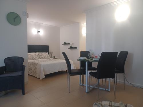 een slaapkamer met een bed en een tafel en stoelen bij Apartamento Golf del Sur in San Miguel de Abona