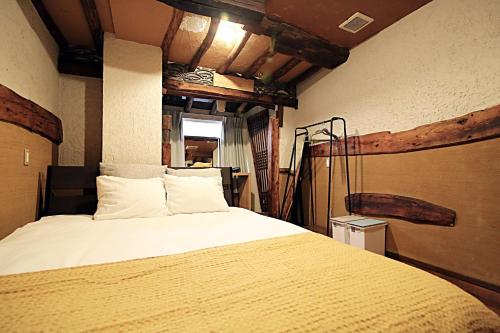 a bedroom with a large bed with white sheets at TOKYO HOUSE INN - Vacation STAY 52042v in Tokyo