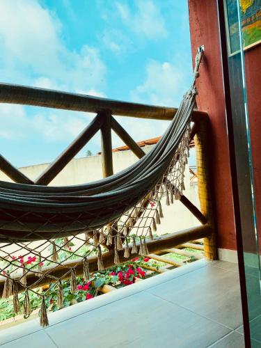 a hammock on top of a building with flowers at Portuá Chalés in São Miguel dos Milagres