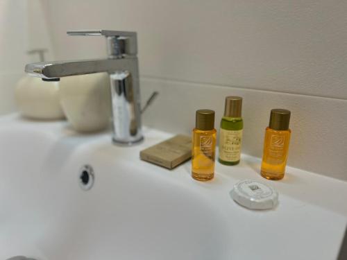 three bottles ofodorizers sitting on a bathroom sink at Il Riccio in Bari