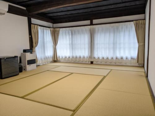 Former inn "Oyado Wada-juku" - Vacation STAY 16383v في Nagawa: غرفة معيشة فارغة مع ستائر وتلفزيون