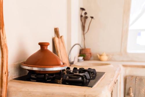 a pot sitting on top of a stove in a kitchen at Desart Hostel in Agadir