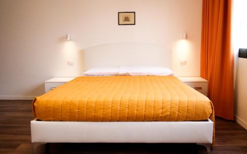 a bedroom with a bed with an orange blanket at Victoria Royal Garden in Como