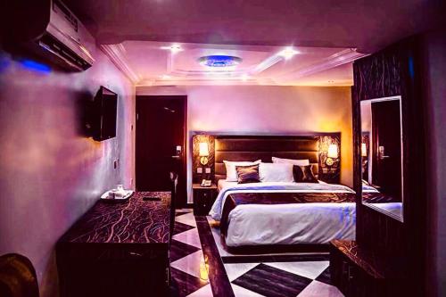 sypialnia z dużym łóżkiem w pokoju w obiekcie E-Suites Hotel, Abuja w mieście Abudża