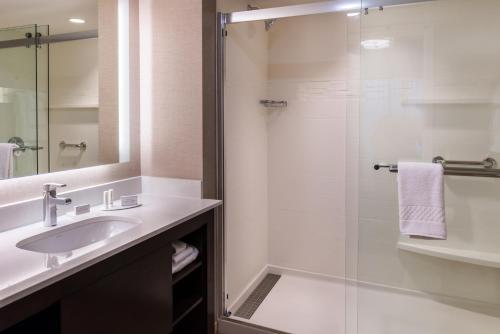 西雅圖的住宿－西雅圖大學區萬豪原住客棧，一间带水槽和玻璃淋浴的浴室