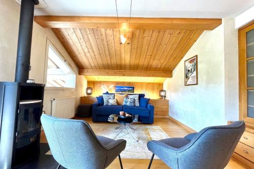 - un salon avec un canapé bleu et des chaises dans l'établissement Perles des Alpes, à Combloux
