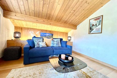 - un salon avec un canapé bleu et un plafond en bois dans l'établissement Perles des Alpes, à Combloux