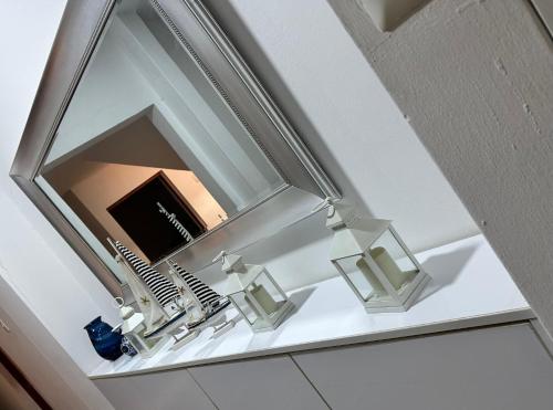 um espelho por cima de uma prateleira branca com escovas de dentes em Casa en San Fernando Pachacamac em Lima