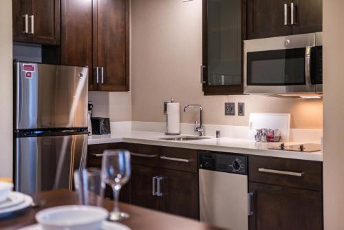 a kitchen with wooden cabinets and a stainless steel refrigerator at Residence Inn by Marriott Seattle University District in Seattle