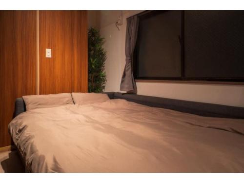 1 cama grande en un dormitorio con ventana en Hakugei Ryokan - Vacation STAY 30349v en Tokio