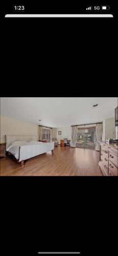 a bedroom with a large bed and a wooden floor at Resort type home in Old Brookvile !!! in Glen Head