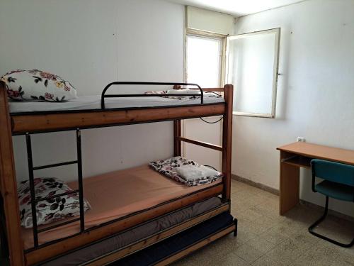 Ce lit se trouve dans un dortoir doté de 2 lits superposés, d'un bureau et d'une fenêtre. dans l'établissement Unforgettable cozy corner in Tzfat, à Safed