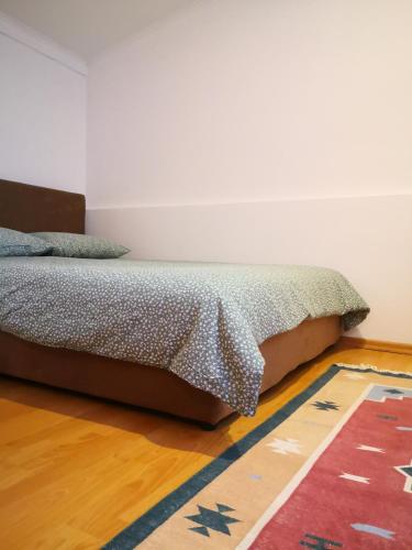 een bed in een slaapkamer met een tapijt bij Apartment Bistrik 1 in Sarajevo