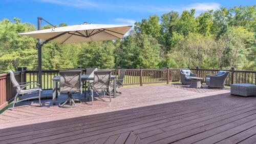 une terrasse avec une table, des chaises et un parasol dans l'établissement Leo Farm Villa - Beautiful Country Retreat villa, à La Plata