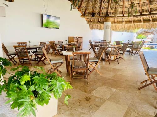 um restaurante com mesas e cadeiras de madeira e uma piscina em Exclusivo Departamento con acceso a playa em Acapulco