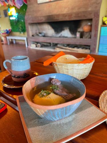 a bowl of soup on a table with two baskets of food at Voyaca Hotel Alfareria in Villa de Leyva