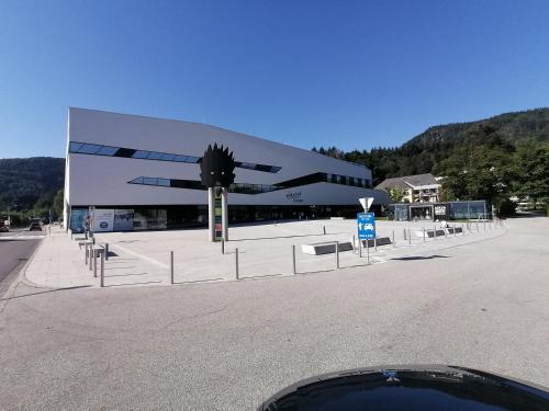 a large building in a parking lot next to a road at Ferienhaus Tolazzi in Arnoldstein