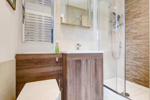 a bathroom with a toilet and a sink and a shower at A Quaint and Delightful Abode in Normanhurst in Carshalton