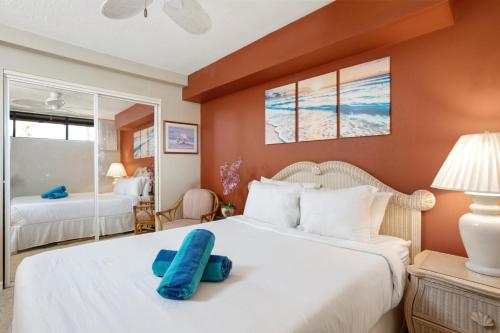 a bedroom with a large bed with a blue pillow on it at KBM Resorts KVR-F405 1 bdrm Includes Rental Car in Kaanapali