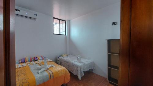 a small bedroom with two beds and a window at CASA DE NOELIA in Puerto Baquerizo Moreno