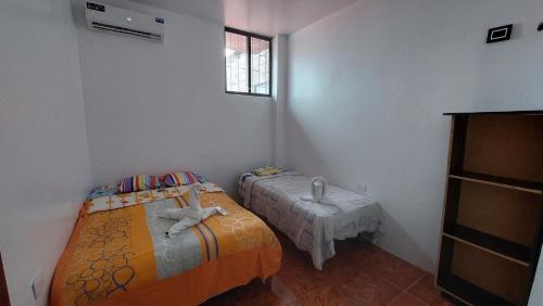 a small room with two beds and a window at CASA DE NOELIA in Puerto Baquerizo Moreno