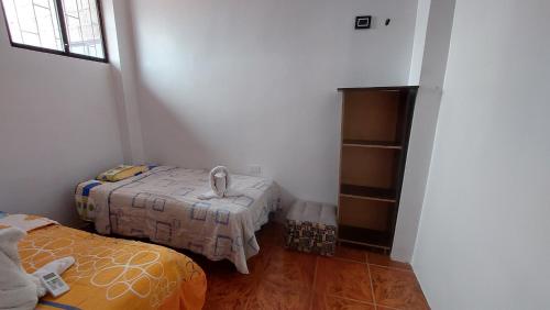 a small room with two beds and a shelf at CASA DE NOELIA in Puerto Baquerizo Moreno