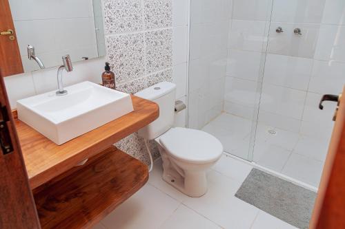 a bathroom with a sink and a toilet and a shower at Chácara Caminho das Águas in Piraquara