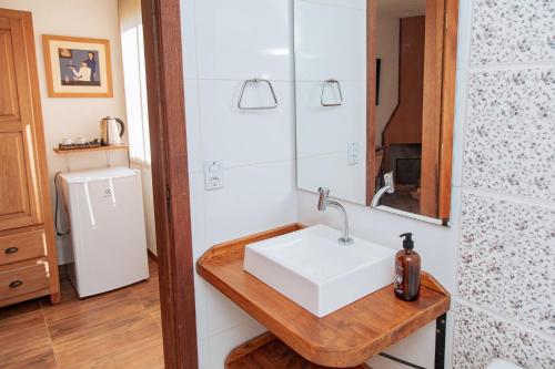 a bathroom with a sink and a mirror at Chácara Caminho das Águas in Piraquara