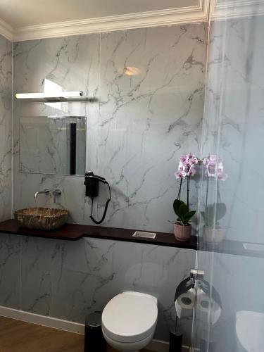 a bathroom with a toilet and a marble wall at D10 Apartments in Breda