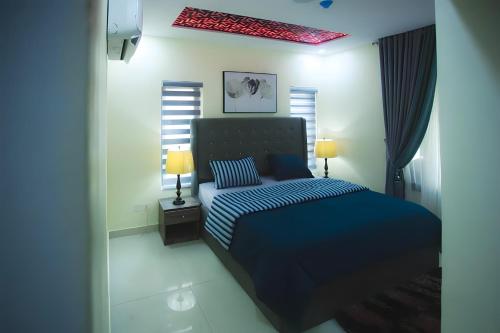 a bedroom with a blue bed and two lamps at Picturesque 3-bedroom Apartment in Yaba in Lagos