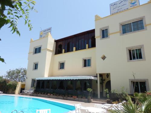 a hotel with a swimming pool in front of a building at Riad Zahra in Essaouira