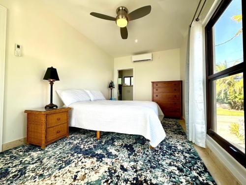 Schlafzimmer mit einem Bett, einem Deckenventilator und einem Fenster in der Unterkunft Seven Mile View Condo #4 in West Bay