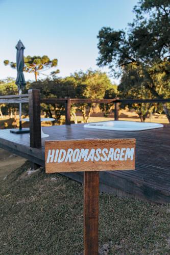 a sign in the grass in front of a table at Chácara Caminho das Águas in Piraquara