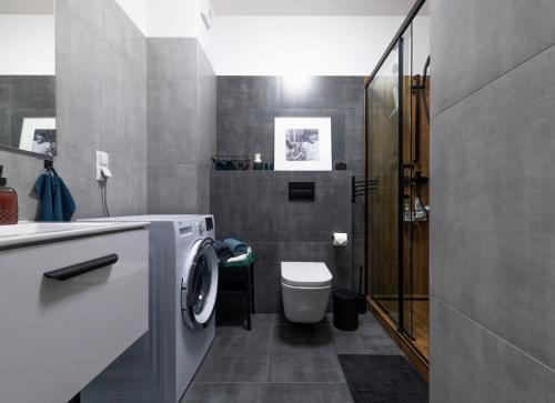a bathroom with a washing machine and a toilet at Apartament doris doris in Poznań