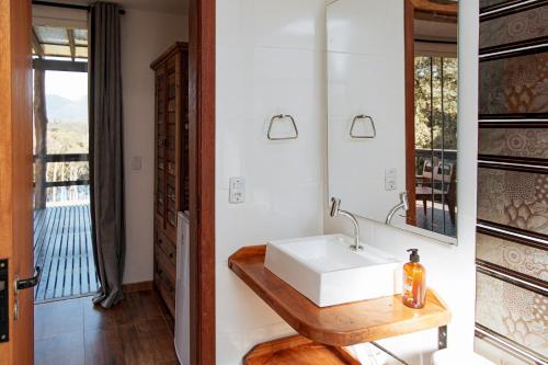 a bathroom with a white sink and a mirror at Chácara Caminho das Águas in Piraquara