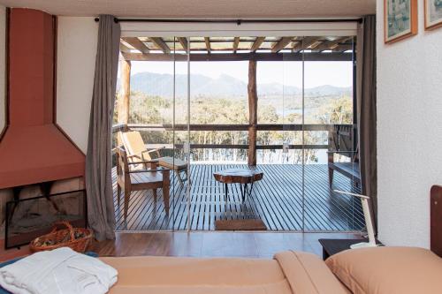 a bedroom with a view of a balcony at Chácara Caminho das Águas in Piraquara