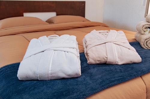 two white towels are sitting on a bed at Chácara Caminho das Águas in Piraquara