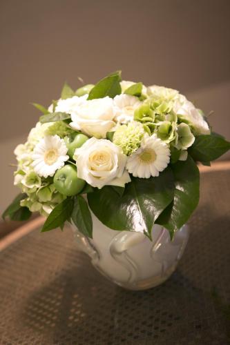 a white vase filled with white flowers on a table at Apartments Ypres in Ypres