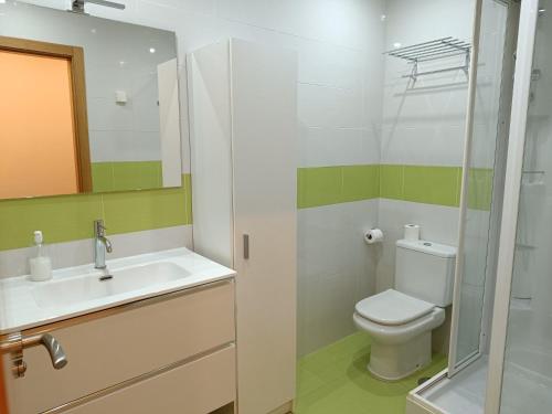 y baño con aseo, lavabo y espejo. en Los Caños de Rivero, con GARAJE y WIFI, VUT-4366-AS en Avilés