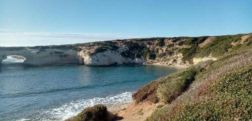a view of a beach with a rock cliff at Da Tziu Efisiu Mare e Relax nel Sinis in Baratili San Pietro