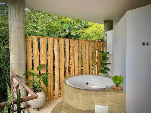een badkamer met een bad en een houten hek bij Satori Home In San Lucas in Medellín