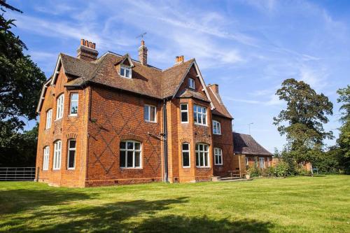 a large brick building on a grass field at The Old Vicarage - sleeps 20 in Kettleburgh