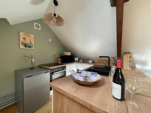 a kitchen with a bottle of wine on a counter at La Bellevue x Parking by Melrose in Bayeux