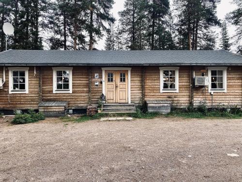 ein Holzhaus mit einer Veranda und einer Tür in der Unterkunft Mellanströms Stugby in Arjeplog